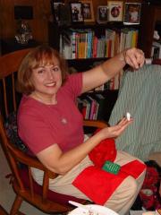 Kathy holding up a necklace with gold pendant